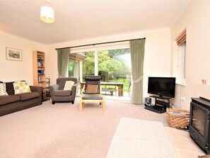 A living room with a sofa, two armchairs, a television, and a fireplace. - 4 Bed in Cromer (oc-kt116) (Cromer)