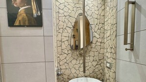 A bathroom with a stone wall, a mirror, a sink, and a painting. - Del Regno Holiday House (Pompei)