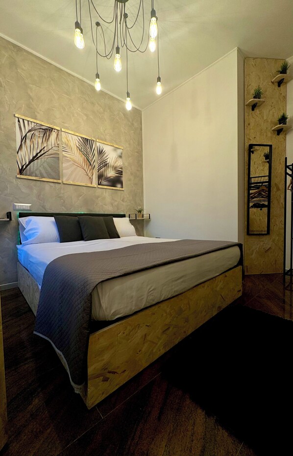 Een slaapkamer met een houten bed, een kroonluchter en wanddecoratie.