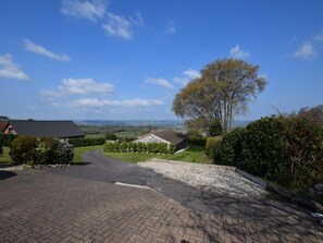 A rural driveway leading to a house with a gravel path and a view of the countryside. - 1 Bed in Axminster (oc-62615) (Axminster)