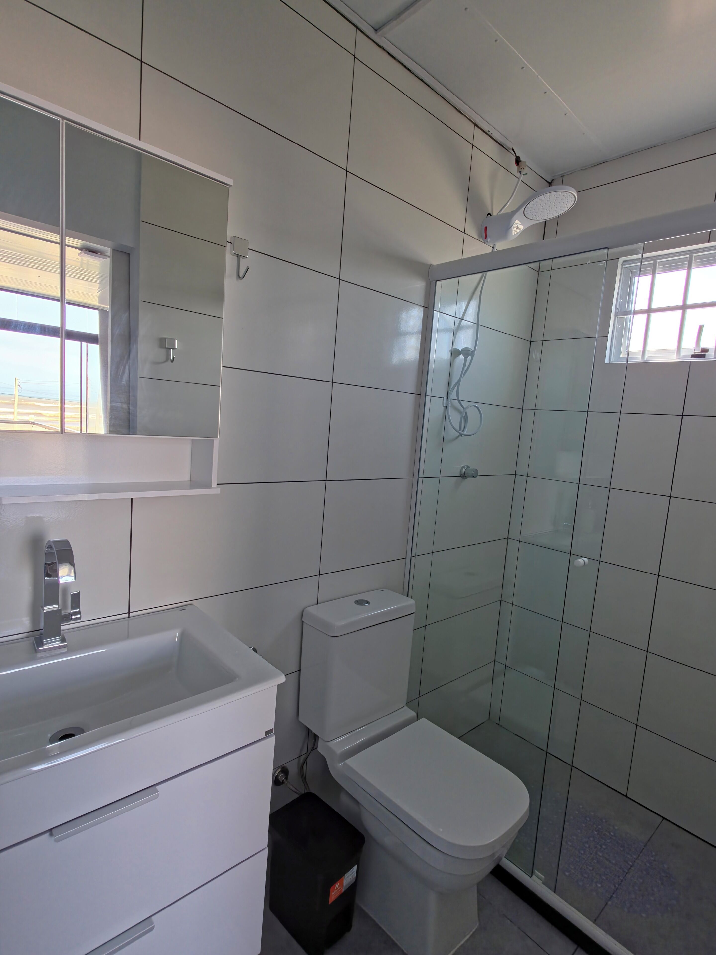 A bathroom with a toilet, sink, and shower.