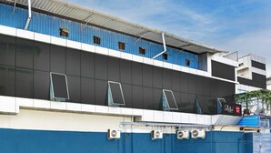 Un edificio a più piani con facciata blu e bianca, ampie finestre e condizionatori.