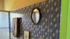Une salle de bain avec un lavabo, un miroir et des carreaux décorés.