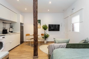 A modern apartment with a kitchen, dining area, and living room. - A studio in the heart of Malasaña's creative quarter, where every corner has been composed like a gallery you get to live in. (MADRID)