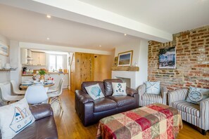 Ein gemütliches Wohnzimmer mit Kamin, Essbereich und Küche.
