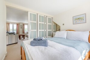 Ein Schlafzimmer mit einem Bett, einer Couch, einem kleinen Tisch und einem Kleiderschrank mit Milchglasschränken.