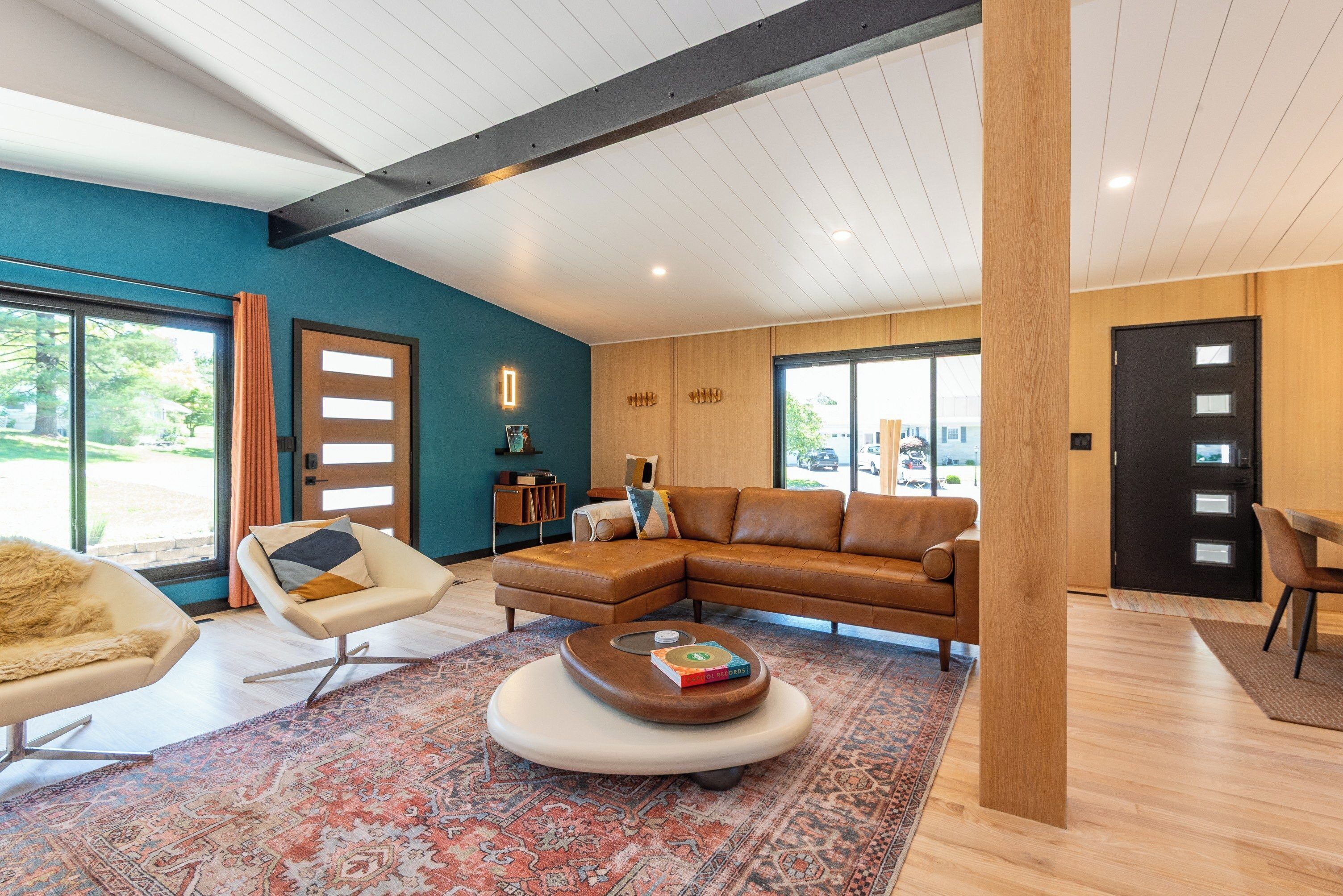 A modern living room with a sectional sofa, a round coffee table, and a patterned rug.