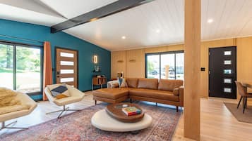 A modern living room with a sectional sofa, a round coffee table, and a patterned rug.