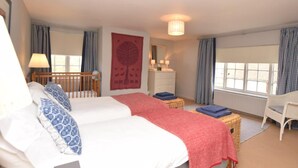 A bedroom with two beds, a dresser, a chair, and a window with curtains. - 3 Bed in Kettlestone (oc-kt037) (Little Snoring)