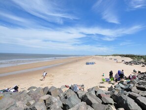 A beach with a rocky foreground, a sandy beach, and a clear sky. - 3 Bed in Thornham (oc-kt022) (Thornham)
