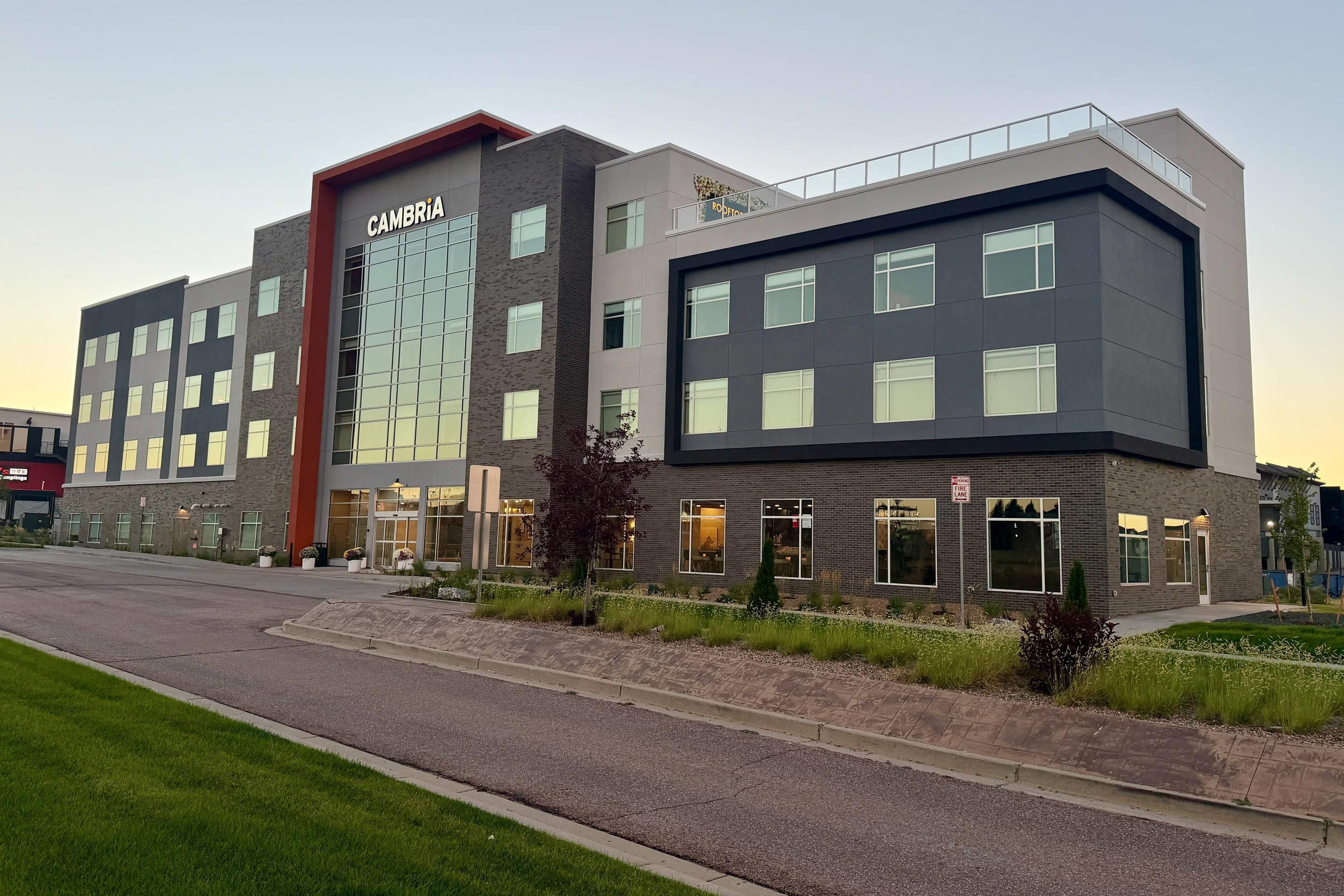 A modern building with a prominent sign reading 'CAMBRIA' and a fire lane sign.