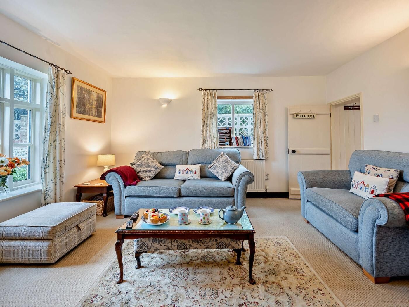 A cozy living room with a sofa set, a coffee table, and a bookshelf.