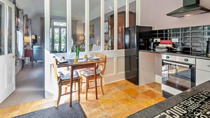 Una cocina moderna con una isla grande, horno integrado y un refrigerador negro.