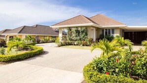 A residential building with a covered patio, landscaped garden, and a driveway. - Coolshade - Richmond Estate  (St. Ann Parish)
