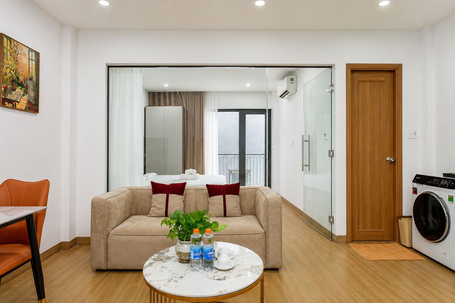 A modern living room with a sofa, a round coffee table, and a washing machine.