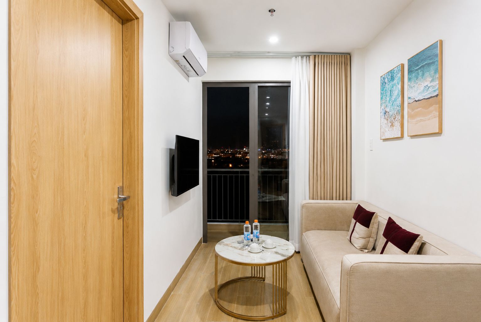Ein modernes Wohnzimmer mit einer Couch, einem runden Couchtisch und einem an der Wand befestigten Fernseher.