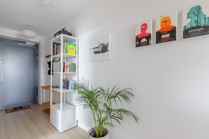 Ein Zimmer mit einem weißen Bücherregal, einem Blumentopf und Star Wars Postern an der Wand.