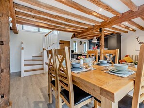 A dining area with wooden beams, a staircase, and a kitchen in the background. - 3 Bed in Salisbury (oc-66130) (Redlynch)