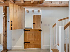 A wooden door with a black handle, a white wall, and a wooden staircase. - 3 Bed in Salisbury (oc-66130) (Redlynch)