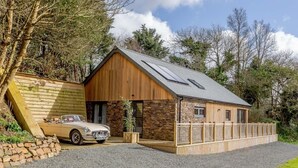 Ein zweistöckiges Haus mit einer Stein-Fassade, einer Garage und einer Auffahrt.