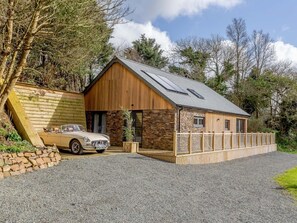Ein zweistöckiges Haus mit einer Stein-Fassade, einer Garage und einer Auffahrt.