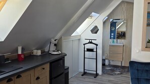 Una cocina moderna con tragaluz, horno empotrado y cafetera.