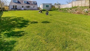 Een woonhuis met een verzorgd gazon, een vrijstaand huis en een kleine schuur.