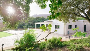 A modern building with a patio area, surrounded by greenery and trees. - Villa La Huerta by Hacienda Alfacara (Benadalid)