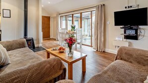 Una sala de estar acogedora con chimenea, televisor y comedor con mesa y sillas.