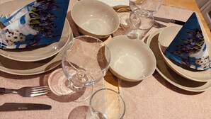 Una tavola imbandita con piatti, ciotole, bicchieri e posate.
