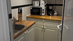 Una cucina dotata di forno a microonde, tostapane, macchina del caffè e lavello.