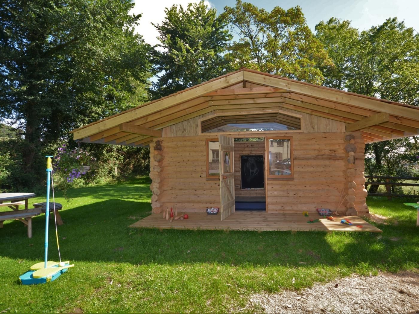 A wooden cabin with a pitched roof, a door, and a small window.