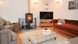 A cozy living room with a fireplace, a television, and comfortable seating. - 3 Bed in North Tawton (oc-66043) (Bondleigh)