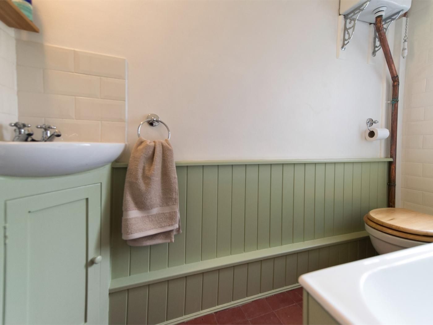 A bathroom with a sink, toilet, and towel rack.