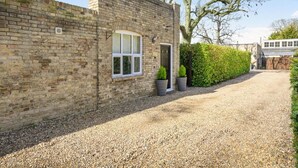 A brick building with a gravel driveway, a door, and a window. - 1 Bed in Beccles (oc-65080) (Beccles)