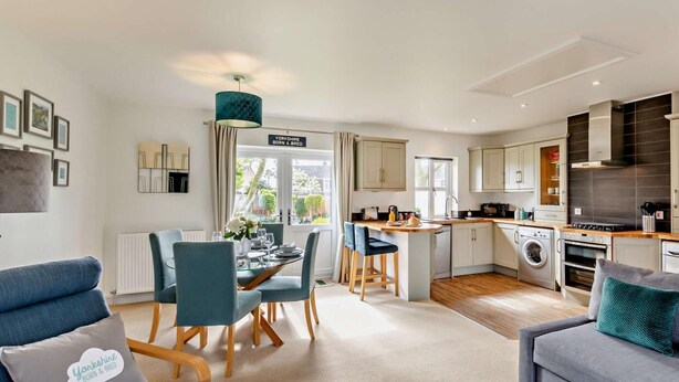 Een modern appartement met een eetgedeelte, keuken en woonkamer.