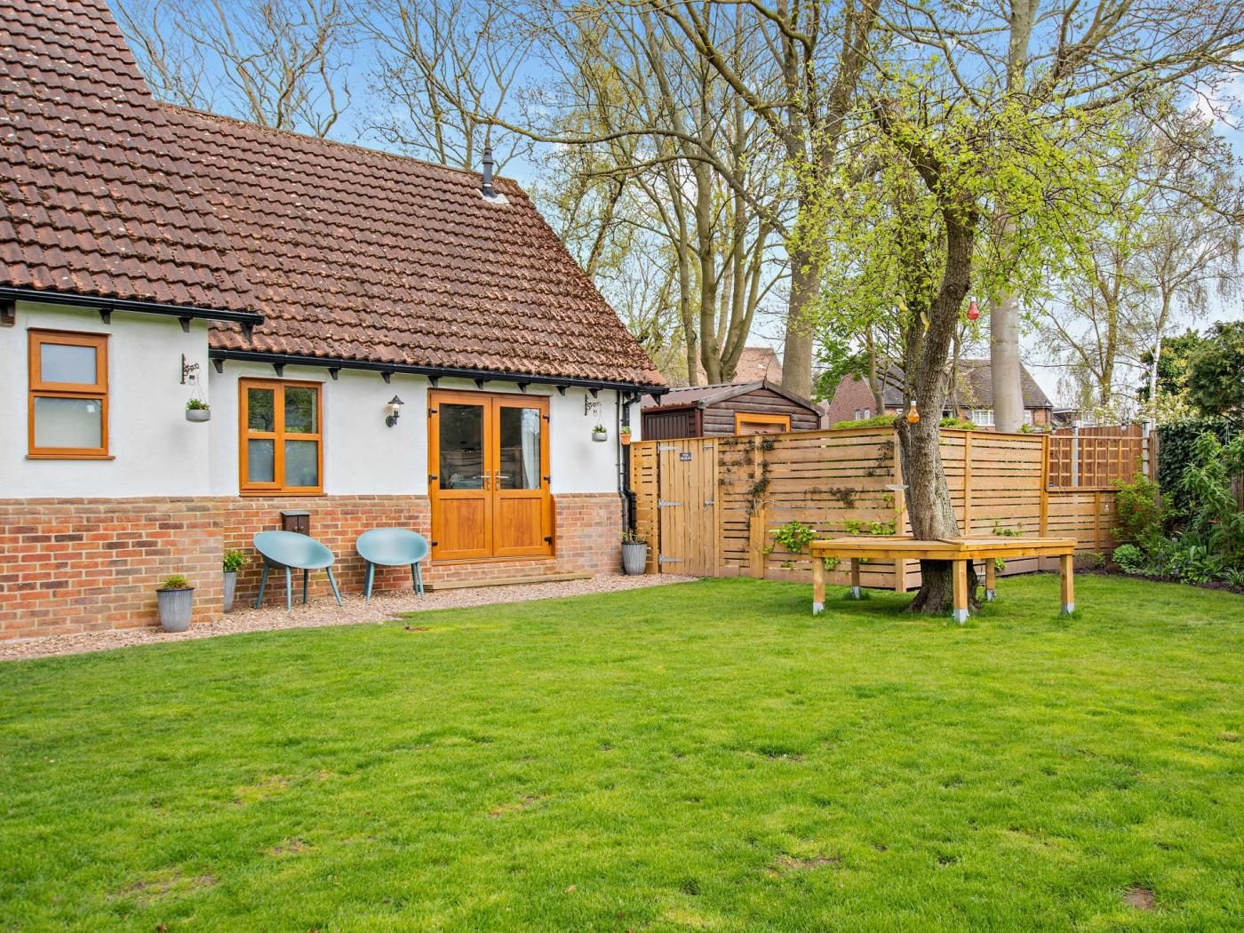 A house with a tiled roof, a brick exterior, and a well-maintained lawn.