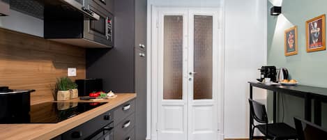 A modern kitchen with a wooden countertop, a built-in oven, and a double door with frosted glass panels.