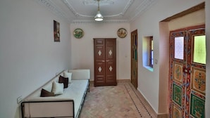 A hallway with a bed, a wardrobe, and a door with intricate designs.