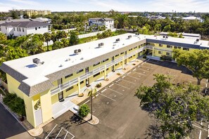 A multi-story hotel with a parking lot and a landscaped area. - 1st floor walk to restaurants and beach (Siesta Key)