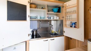 Una cocina funcional con pileta, estufa y alacenas.
