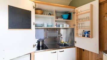 A compact kitchen with a sink, stove, and storage cabinets.
