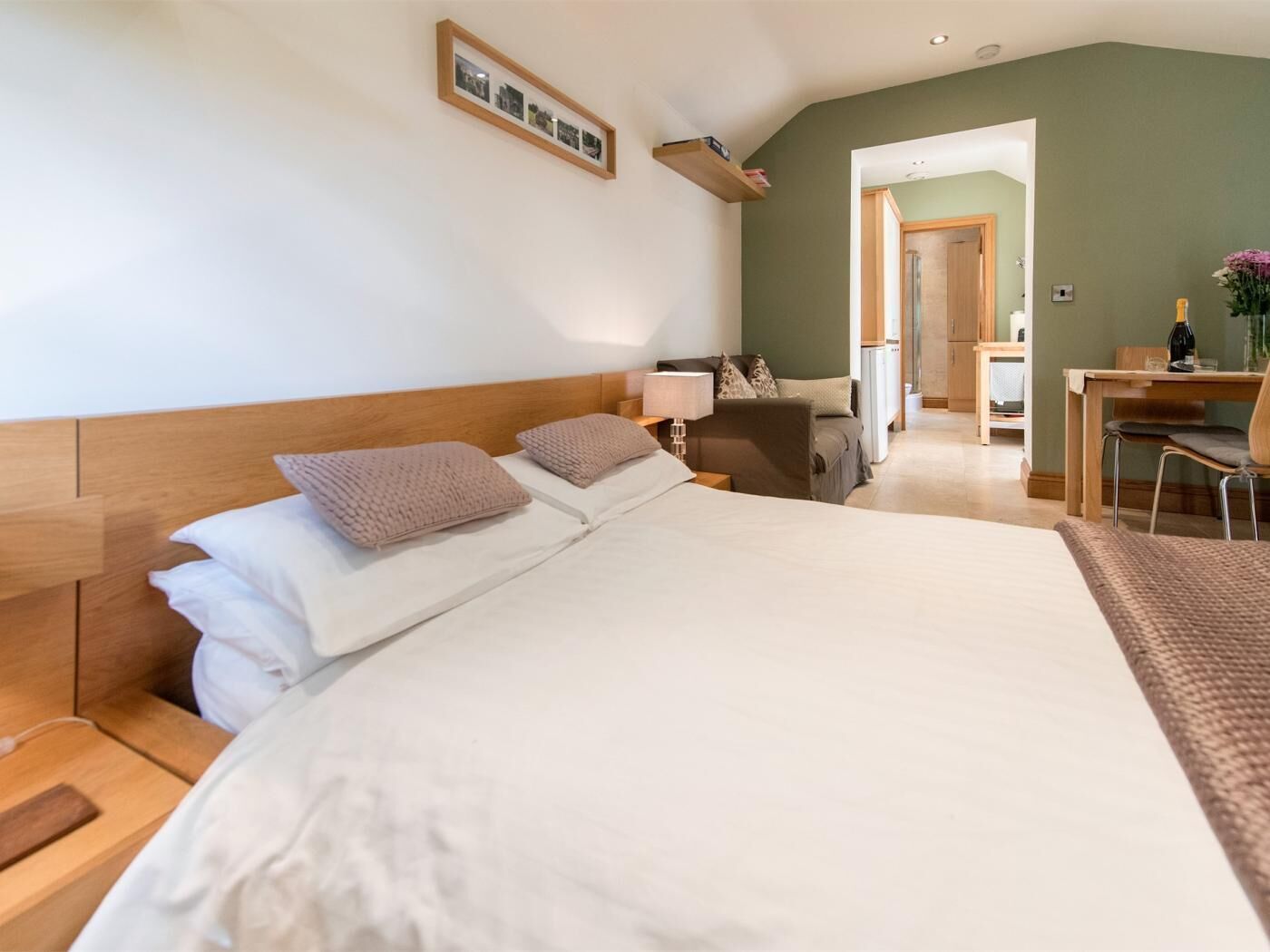 A bedroom with a large bed, a desk, and a chair.