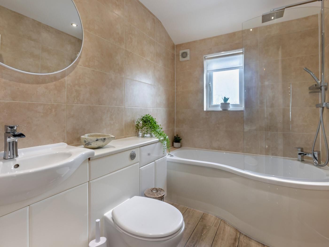 Une salle de bain moderne avec une baignoire, des toilettes, un lavabo et une petite fenêtre.