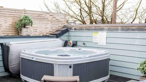 A hot tub with a step, a wooden fence, and a small potted plant. - 3 Bed in Bideford (oc-64410) (Northam)
