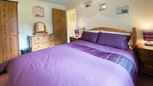 Une chambre à coucher avec un grand lit, une armoire en bois, une commode et des tables de chevet.