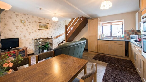 Un salon chaleureux avec une table à manger en bois, un téléviseur et une cheminée.