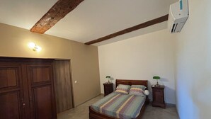 Una camera da letto con un letto, due comodini con lampade, un armadio e un condizionatore d'aria.