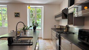 Una cucina moderna con isola centrale, elettrodomestici in acciaio inossidabile e vista sul verde circostante.