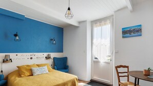 Une chambre à coucher avec un lit, une chaise, une table et une fenêtre.